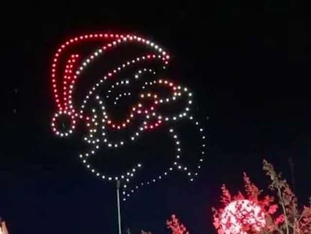 A nighttime light display outlines Santa wearing a red hat.