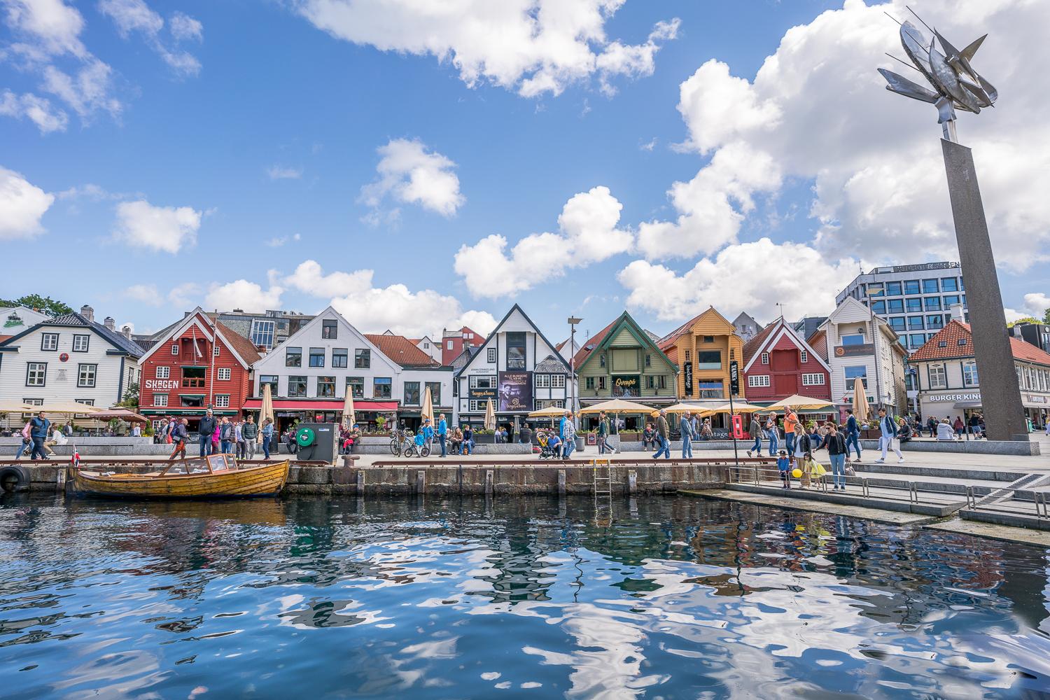 Fargerike sjøhus langs Vågen i Stavanger sentrum, med båter og folkeliv ved sjøkanten.