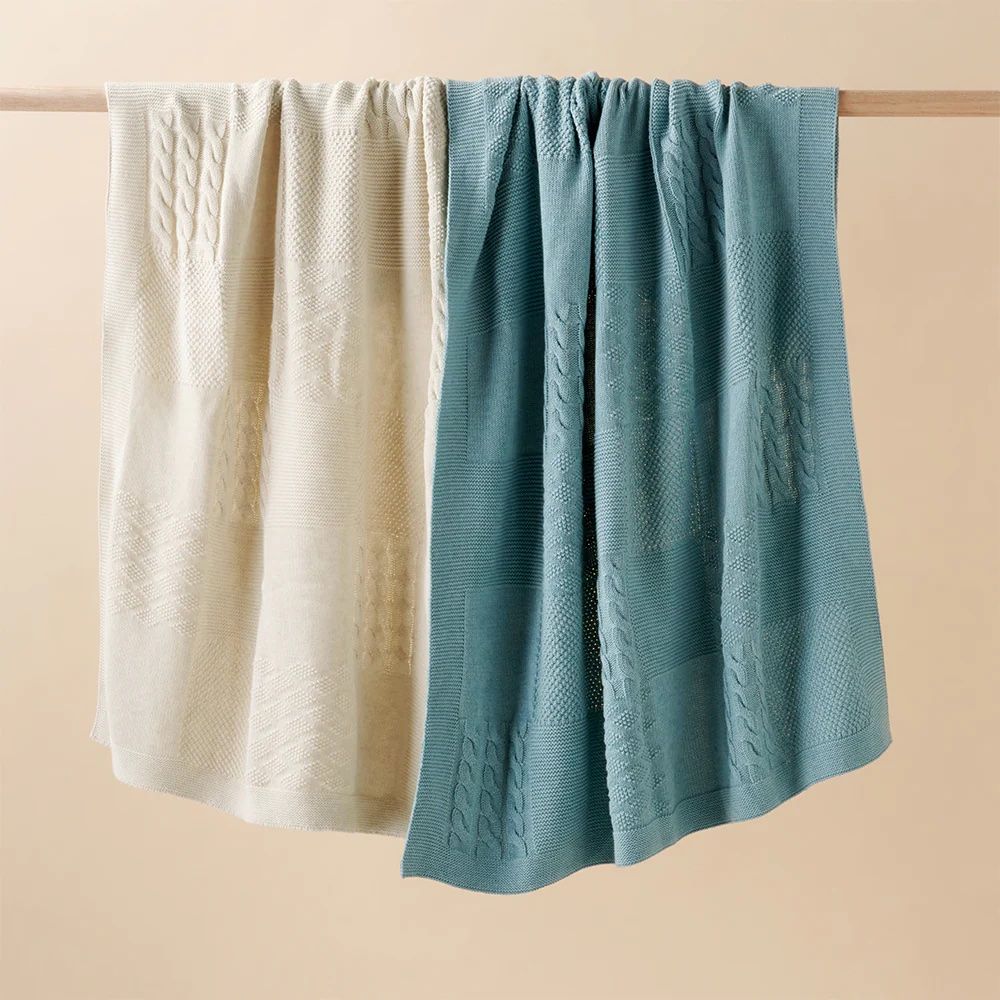 Green and neutral blankets hanging 