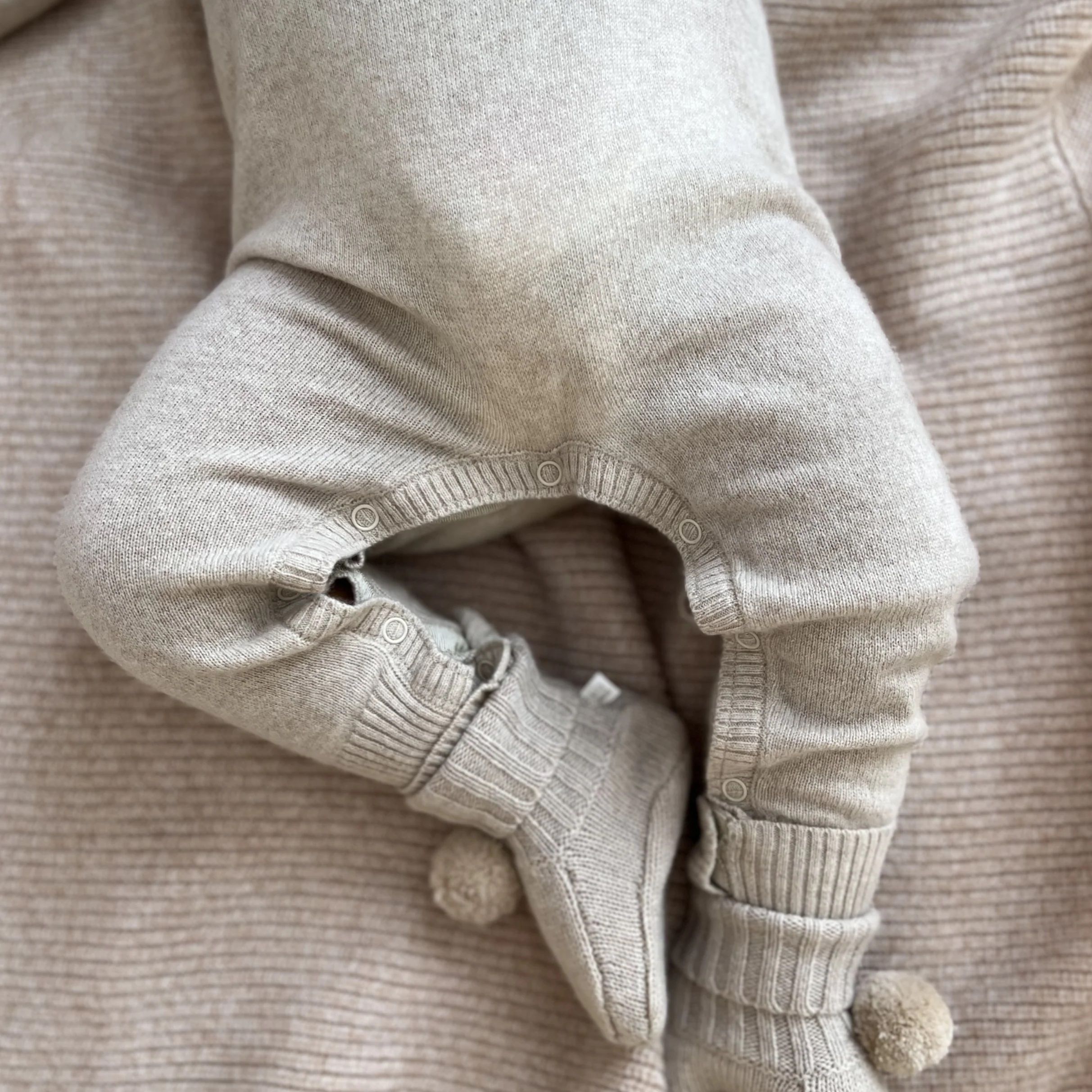 Cashmere growsuit and booties worn on laying baby