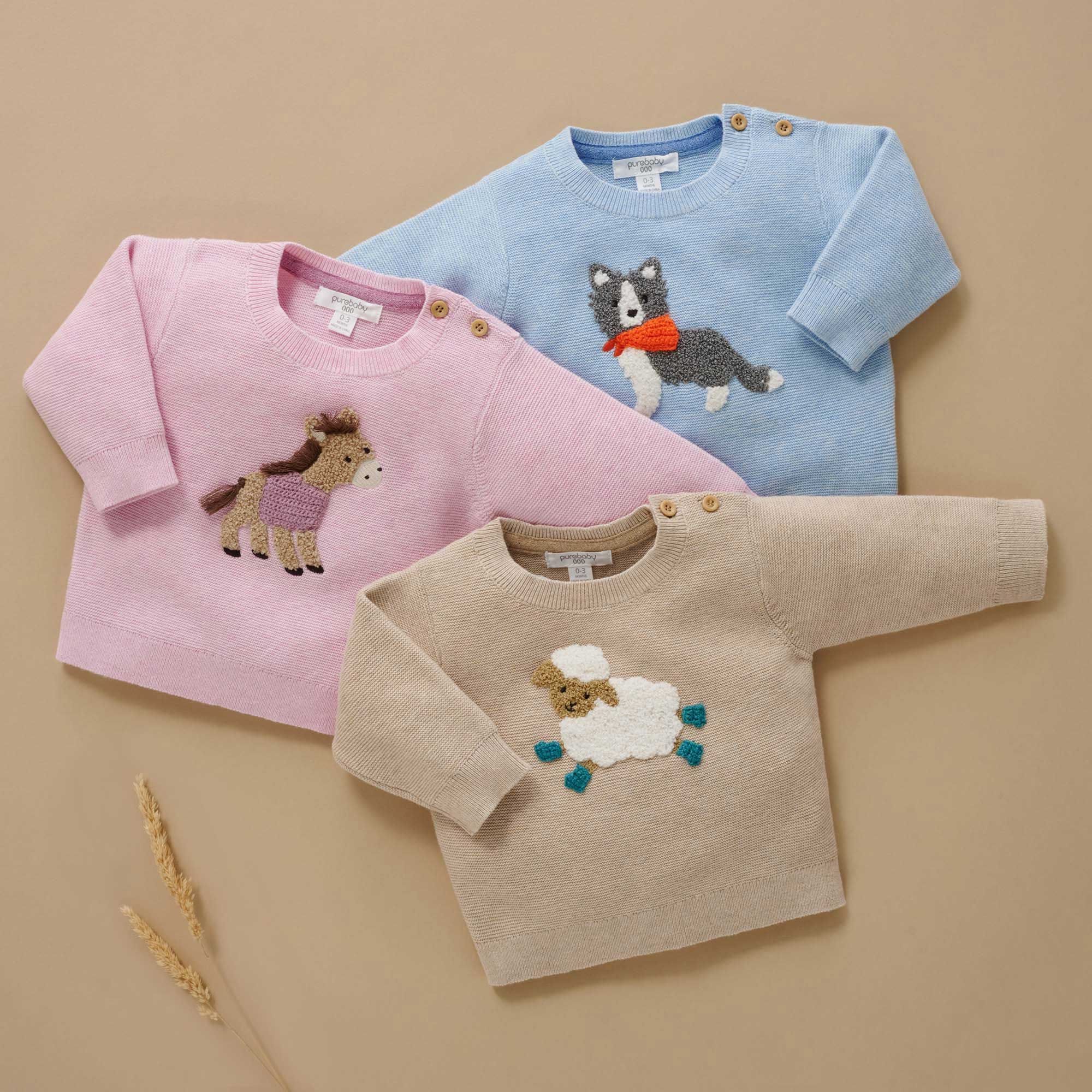Three organic cotton knit baby jumpers with farm animal motifs