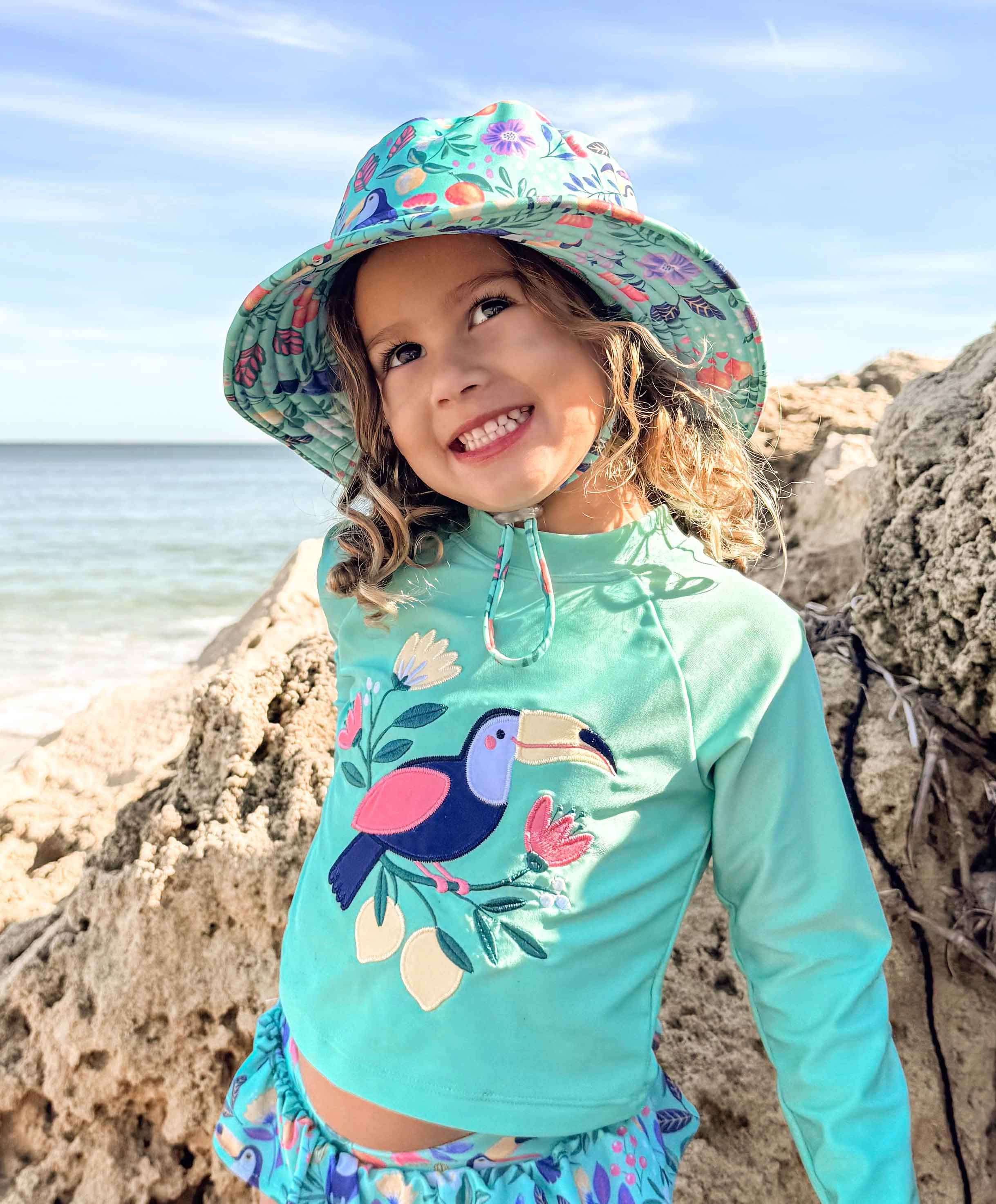 Toddler wearing a Purebaby hat while playing outdoors