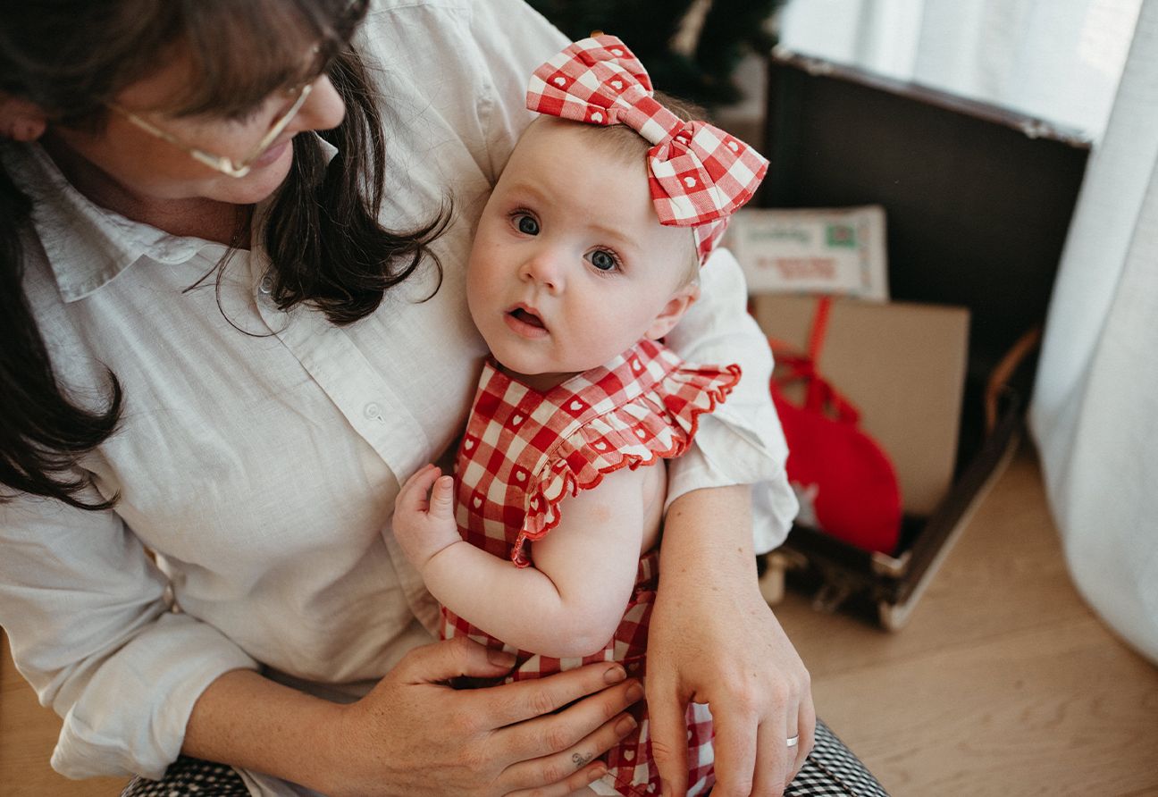 mother holding a baby wearing a Purebaby bodysuit