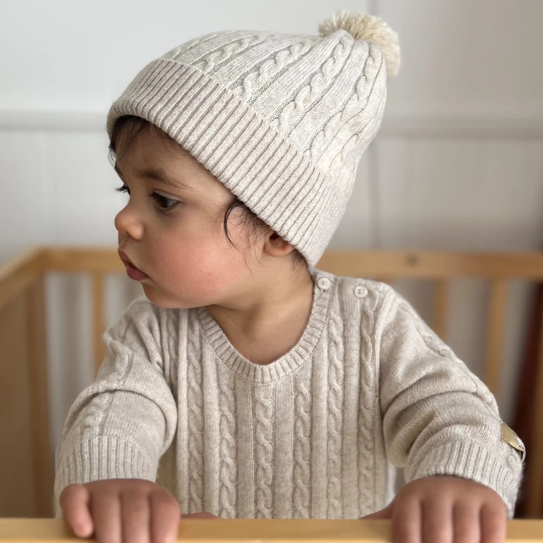 Baby wearing cashmere growsuit and beanie