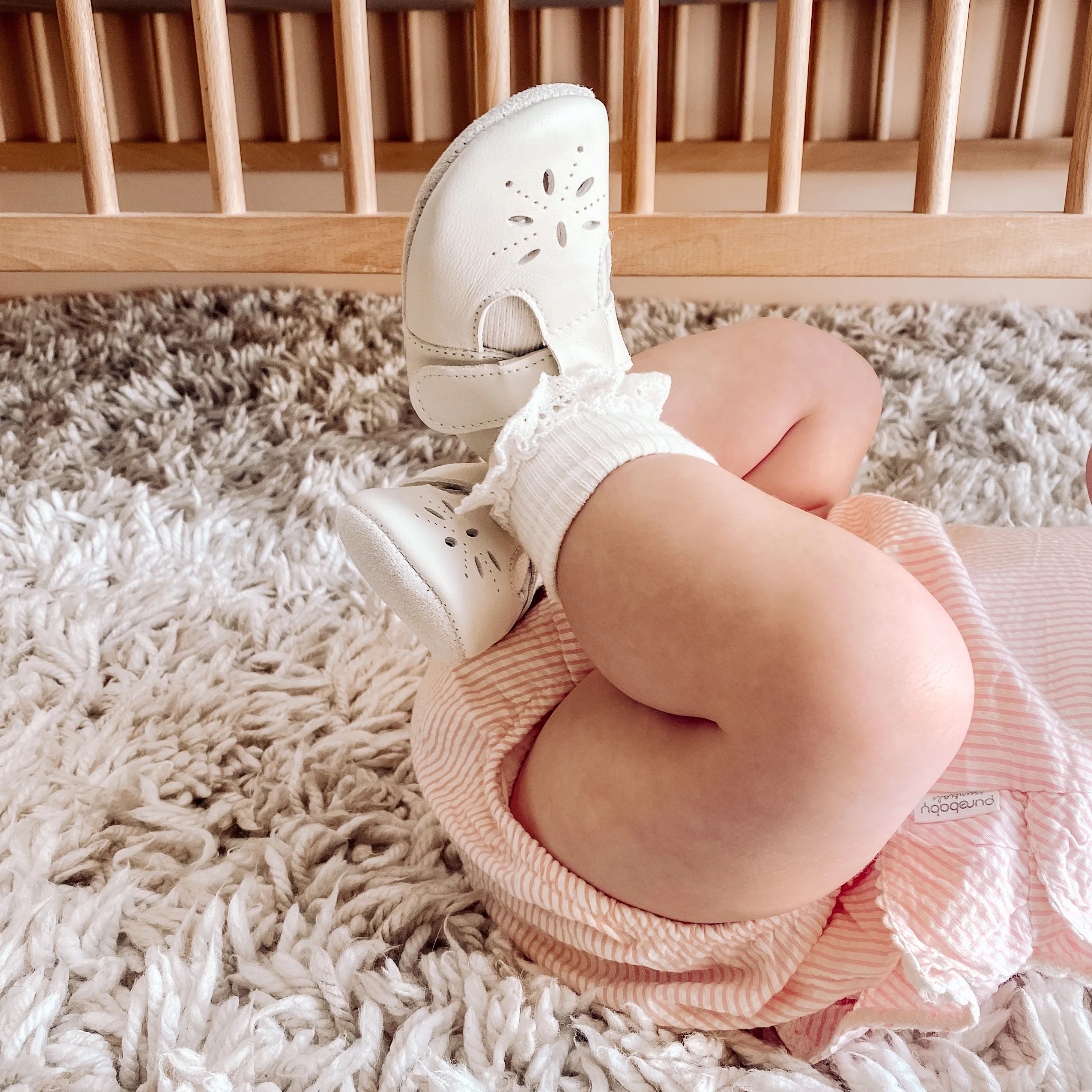 Baby with leggings in air wearing shoes