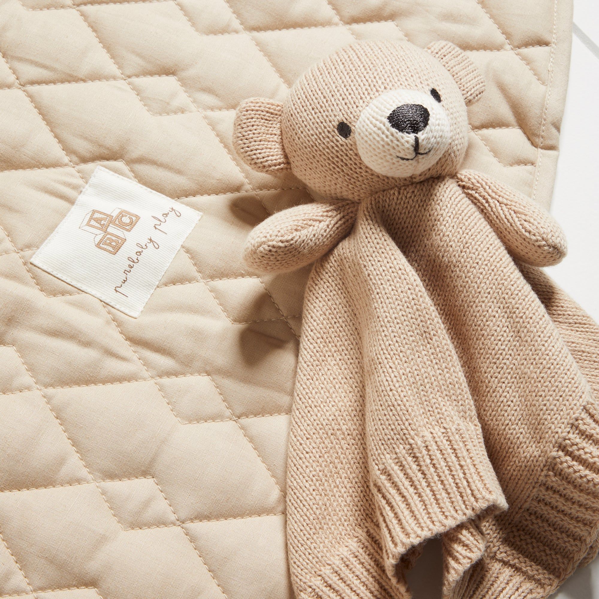 Bear comforter laying on play mat