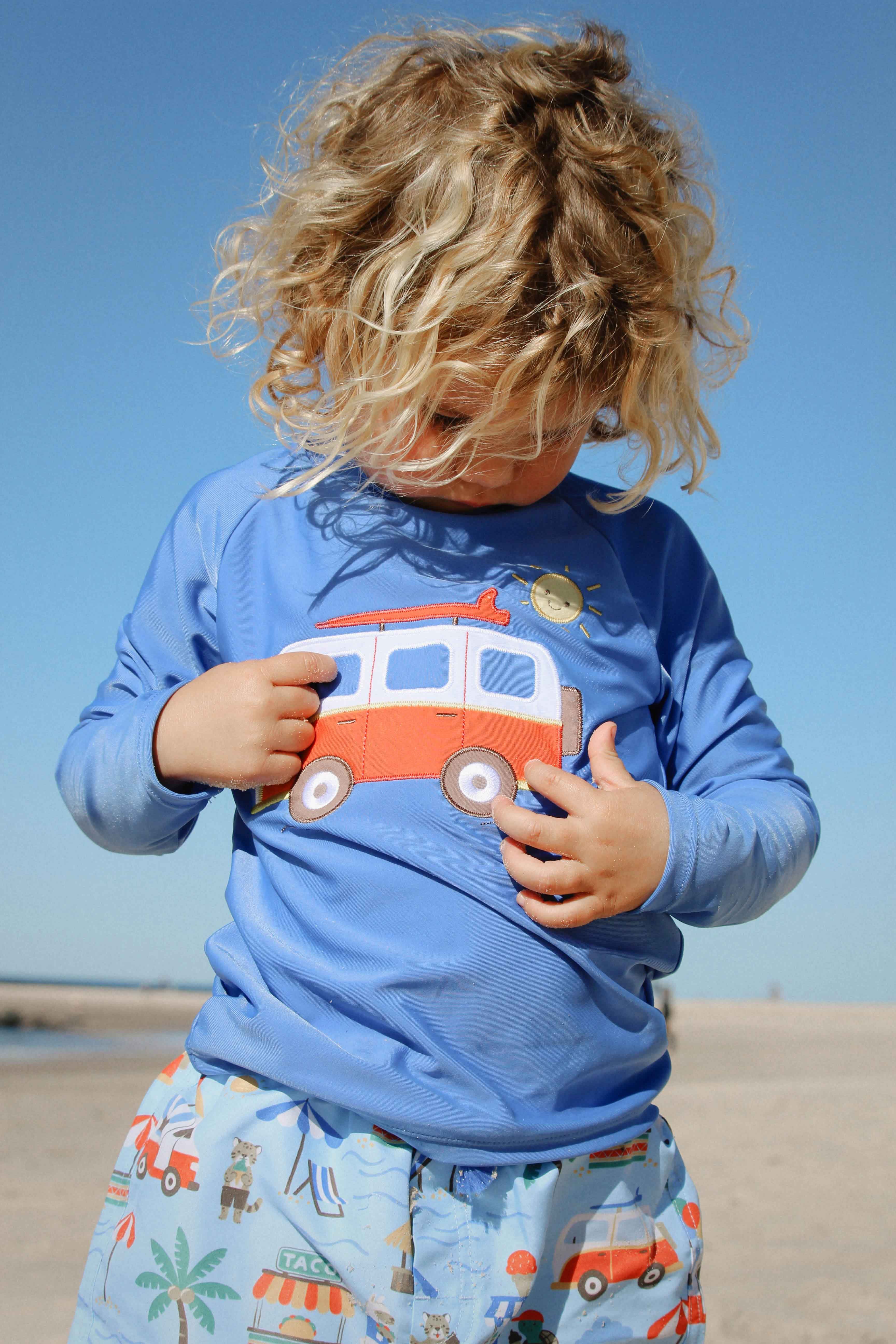 Child wearing a long sleeve kids rash vest with cancun at the beach.