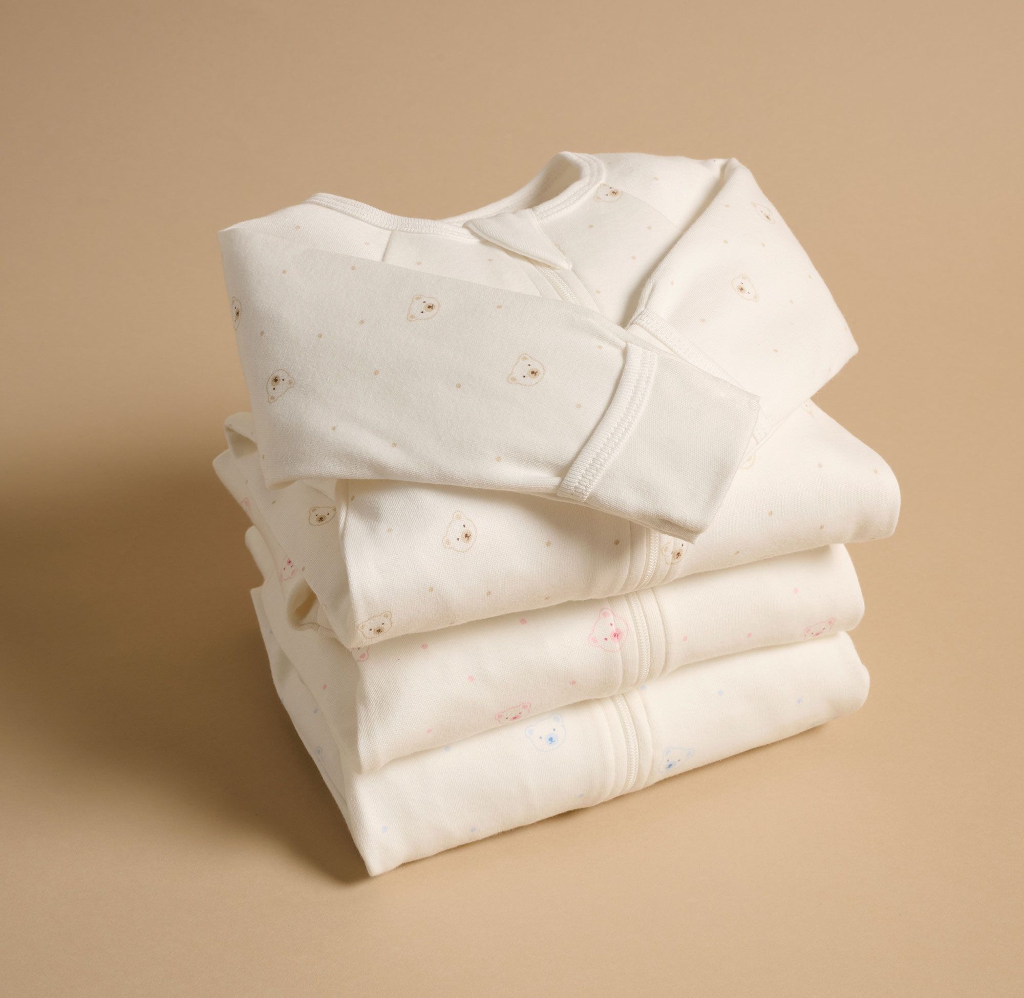 Organic cotton baby clothes folded neatly for the Purebaby Pre-Loved Program