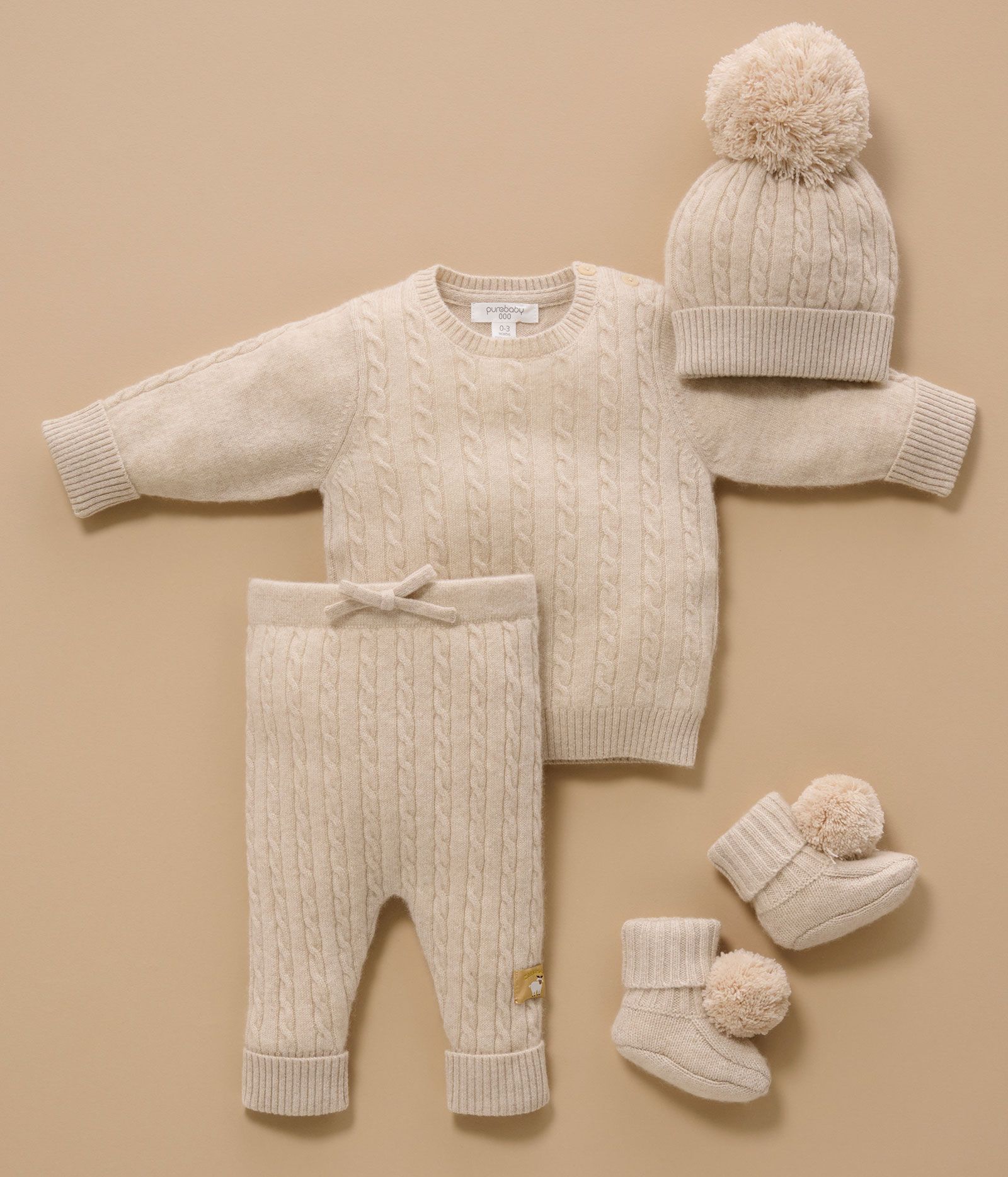 Cashmere baby clothing laying on floor