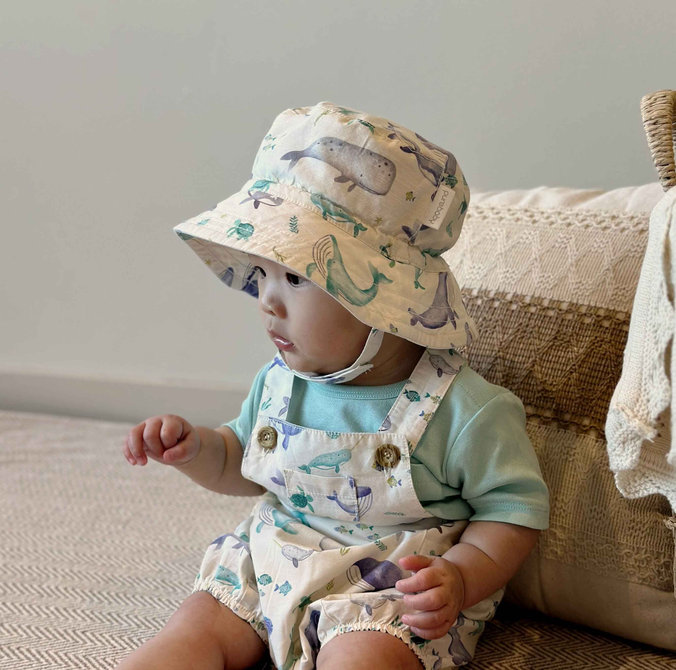 [Image placeholder: Close-up of Purebaby sun hat features: chin strap, wide brim, breathable fabric