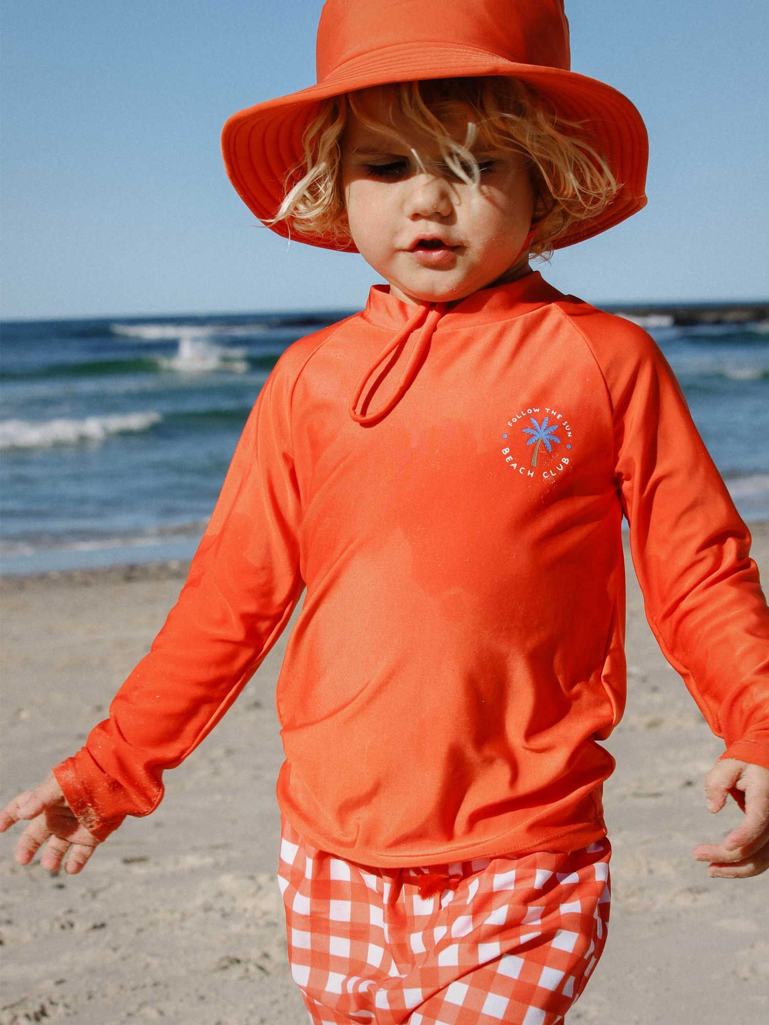 toddler in Purebaby rashie and swim shorts made from REPREVE fabric