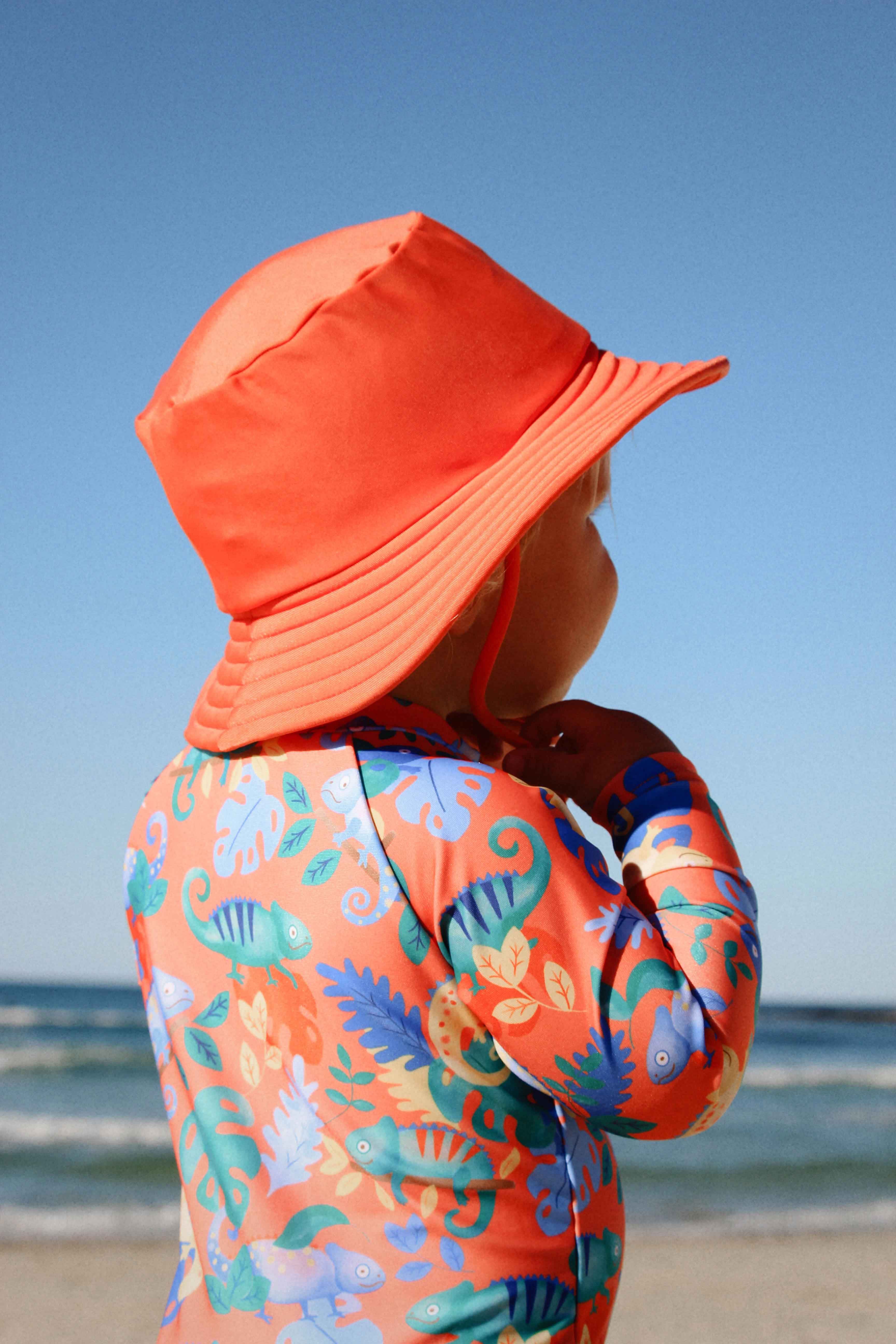 Child in swimwear and hat at beach