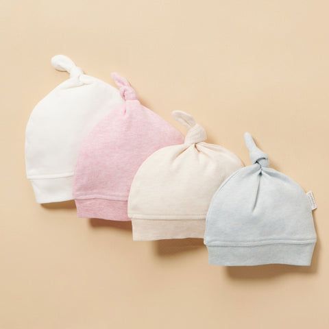 4 overlapping Purebaby baby knot hats in different colours