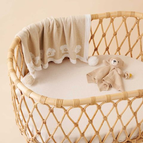 Wooden bassinet with Purebaby pom pom blanket and bear comforter