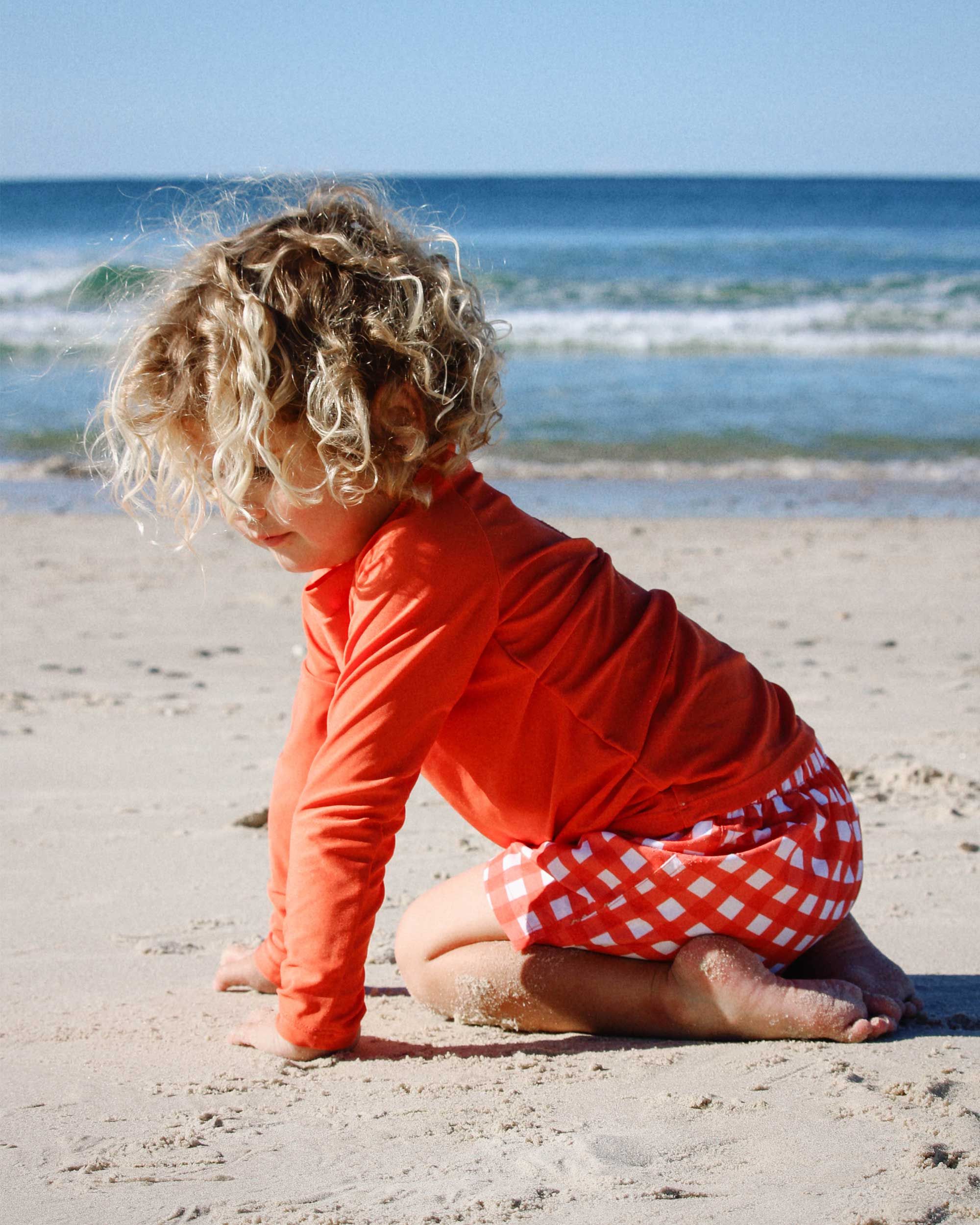 Baby in a long sleeve Purebaby rashie at the beach