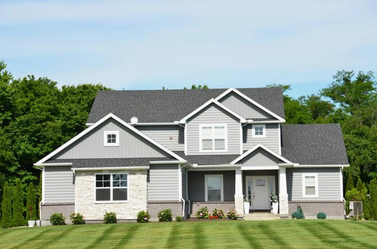 A bright modern house exterior with a green lawn and trees on a calm daylight street — lendsimpl guide to mortgage buyouts after separation in Ontario