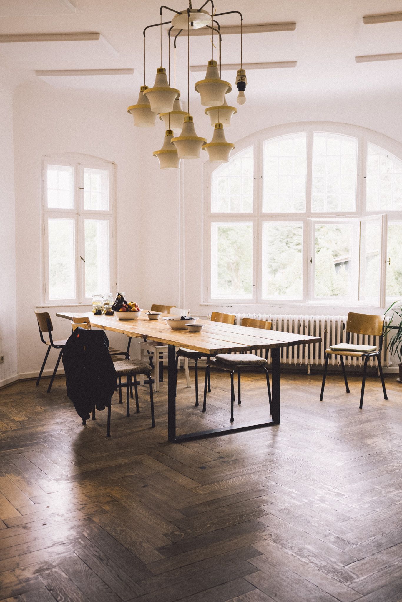 Kleiner Saal in der Villa Neupitz mit Bogenfenstern, Kronleuchter und langem Holztisch