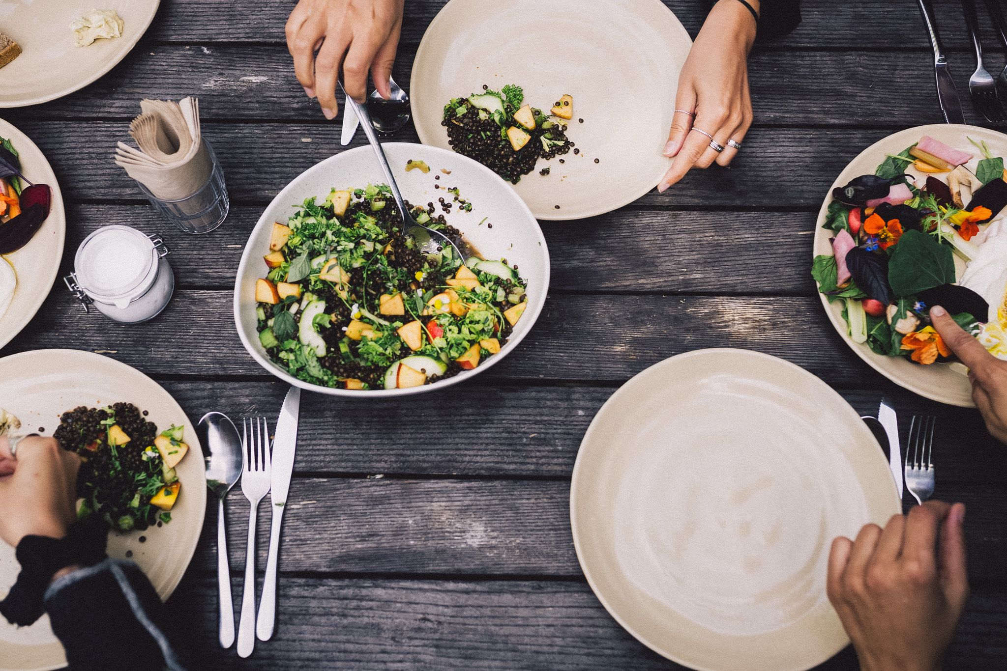 Vegetarische Salate in Schalen auf einem Holztisch, frisch gekocht beim Team-Retreat
