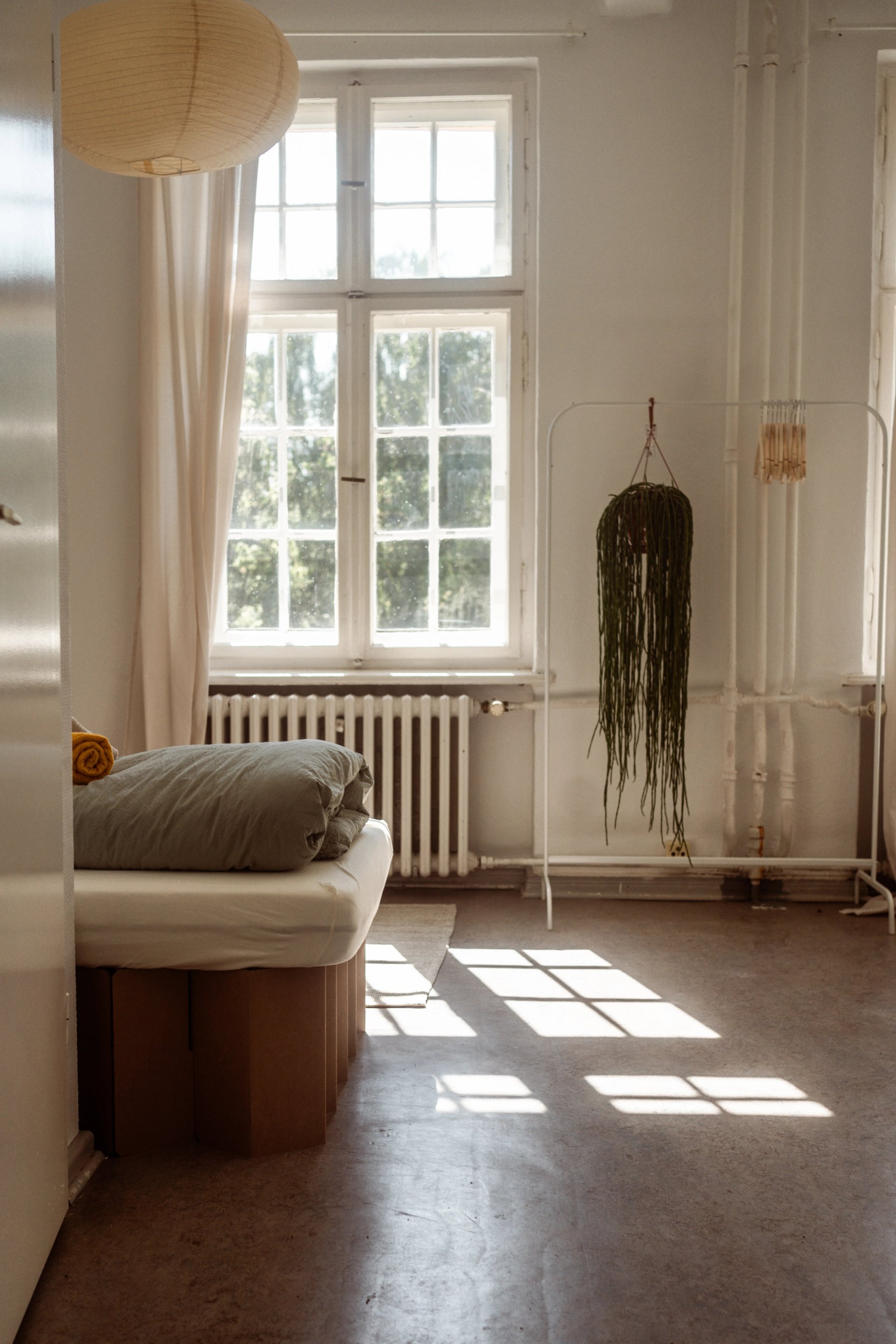 Schlichtes Zimmer in der Villa mit hohem Sprossenfenster und Bett, Gruppenunterkunft für Team-Retreats