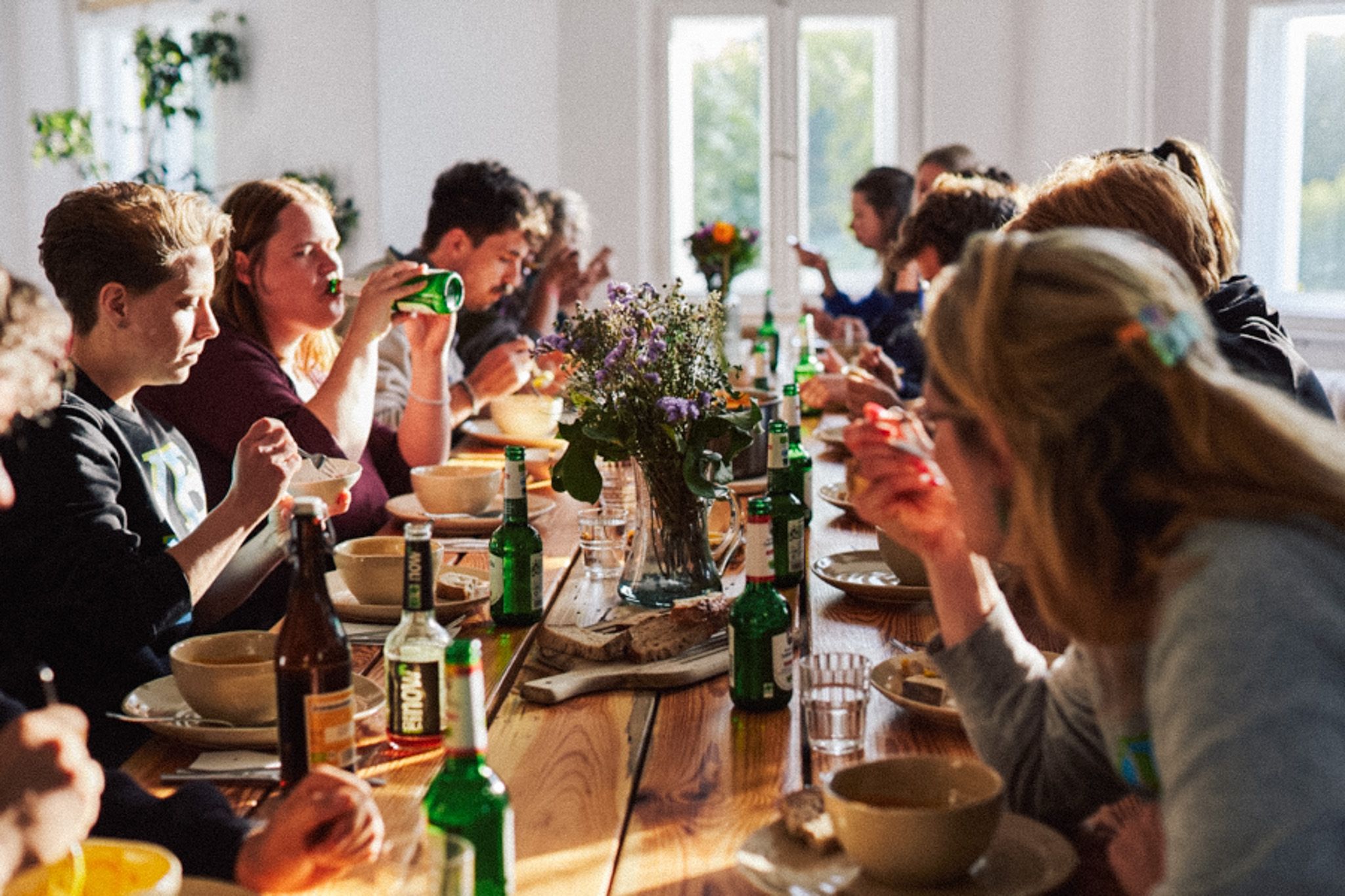 Gruppe beim gemeinsamen Essen an der langen Tafel im Kleinen Saal der Villa Neupitz