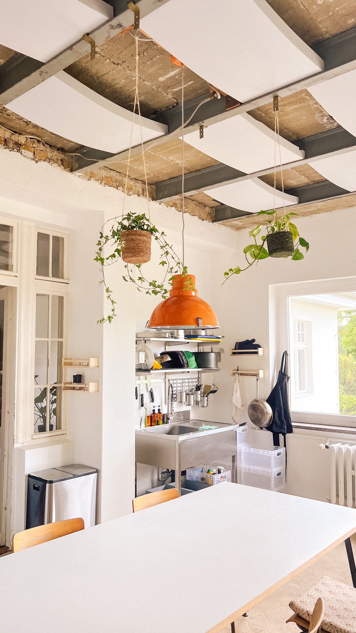 Wintergarten mit Akustikpaneelen an der Decke, Küchenregal und Arbeitstisch