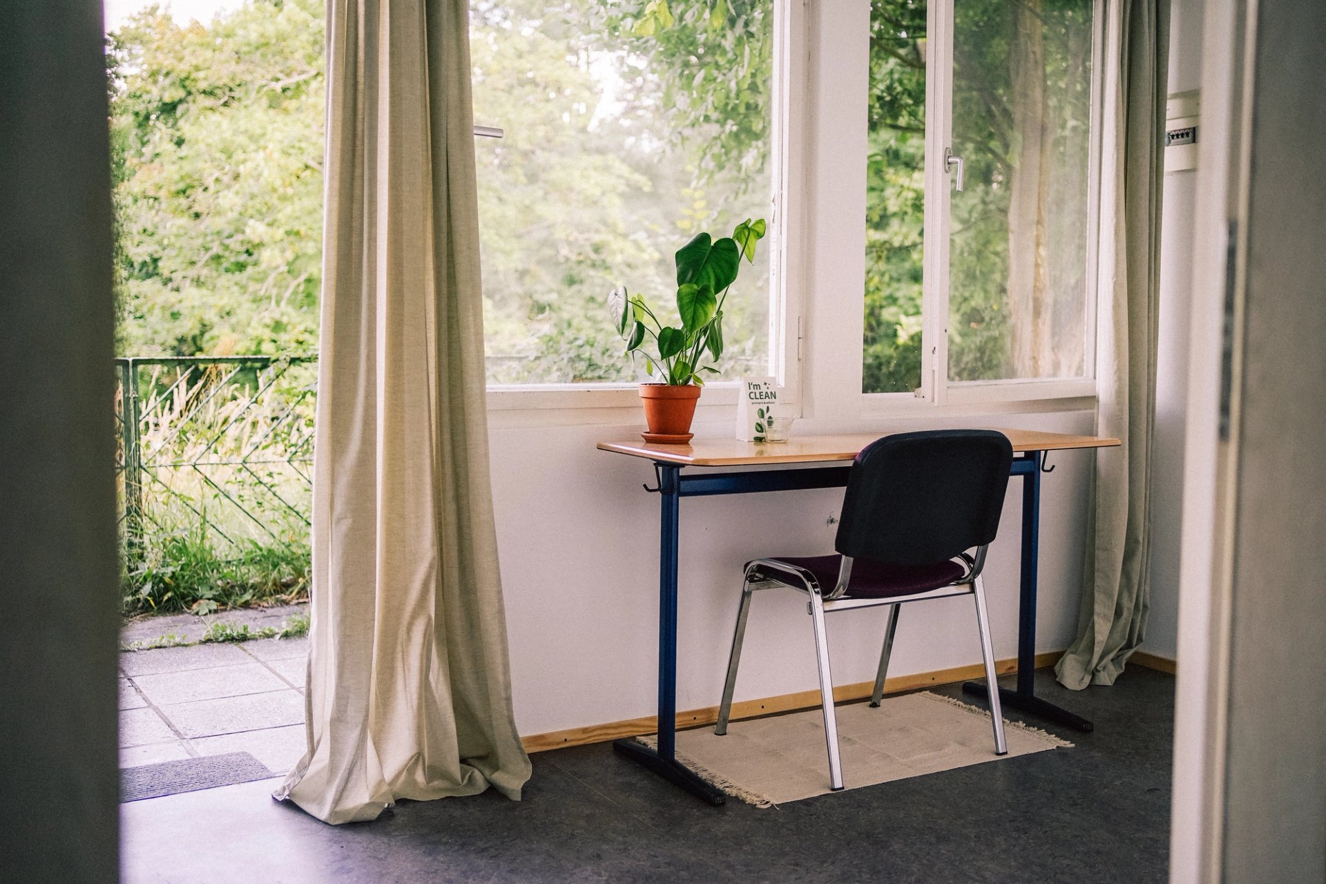 Arbeitsplatz mit Schreibtisch am Fenster und Tür zur Terrasse, ideal für Workation im Grünen