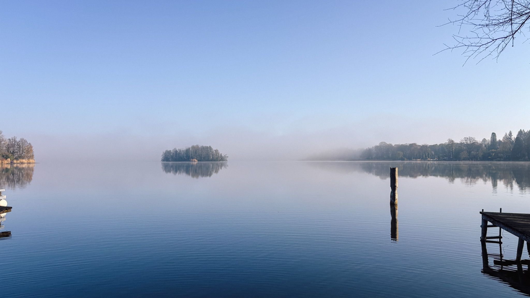 Morgennebel über dem stillen Teupitzer See mit Insel und Steg, Brandenburg