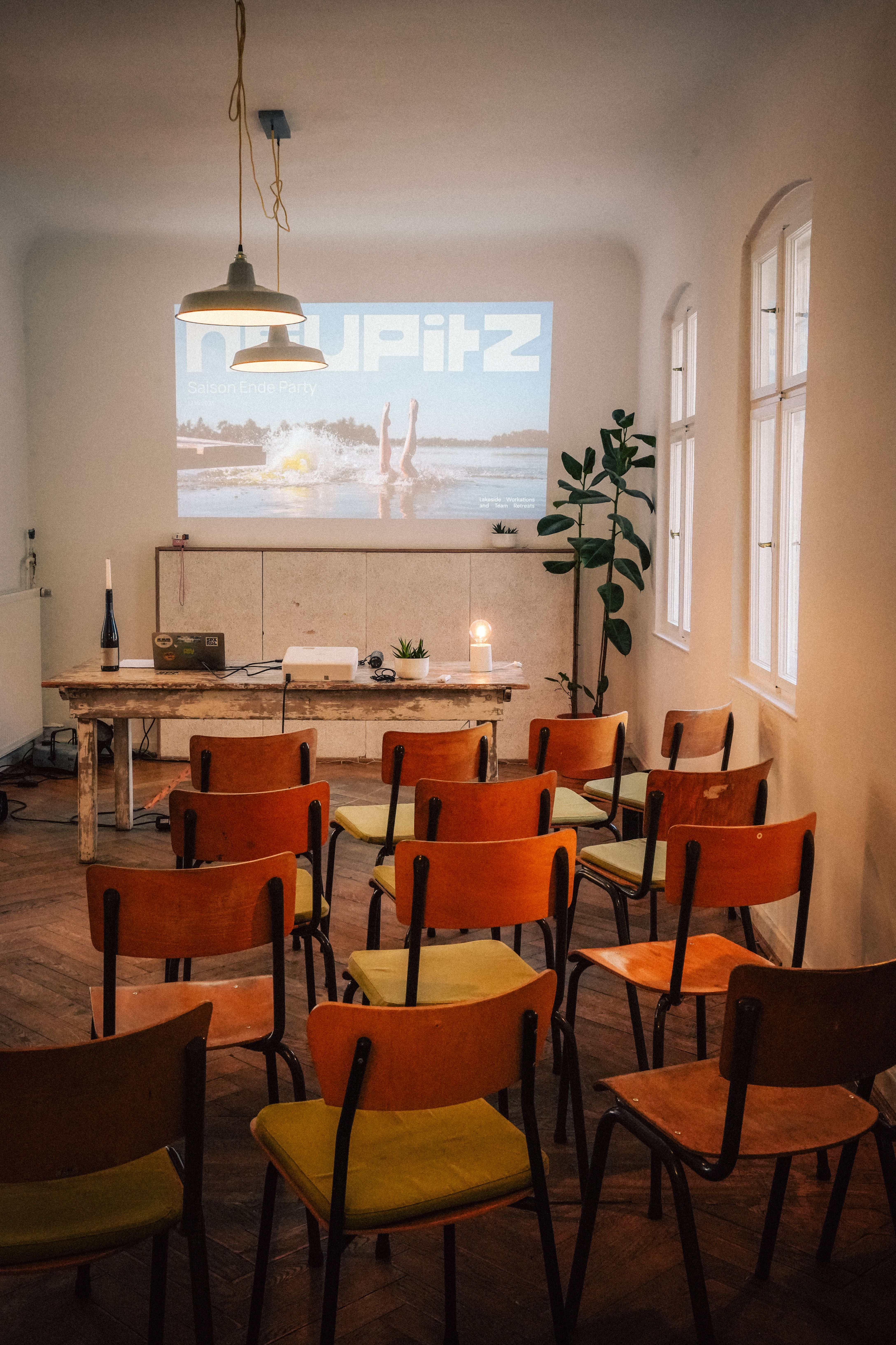 Stuhlreihen vor einer Leinwand im Großen Saal, Setup für Präsentationen beim Offsite