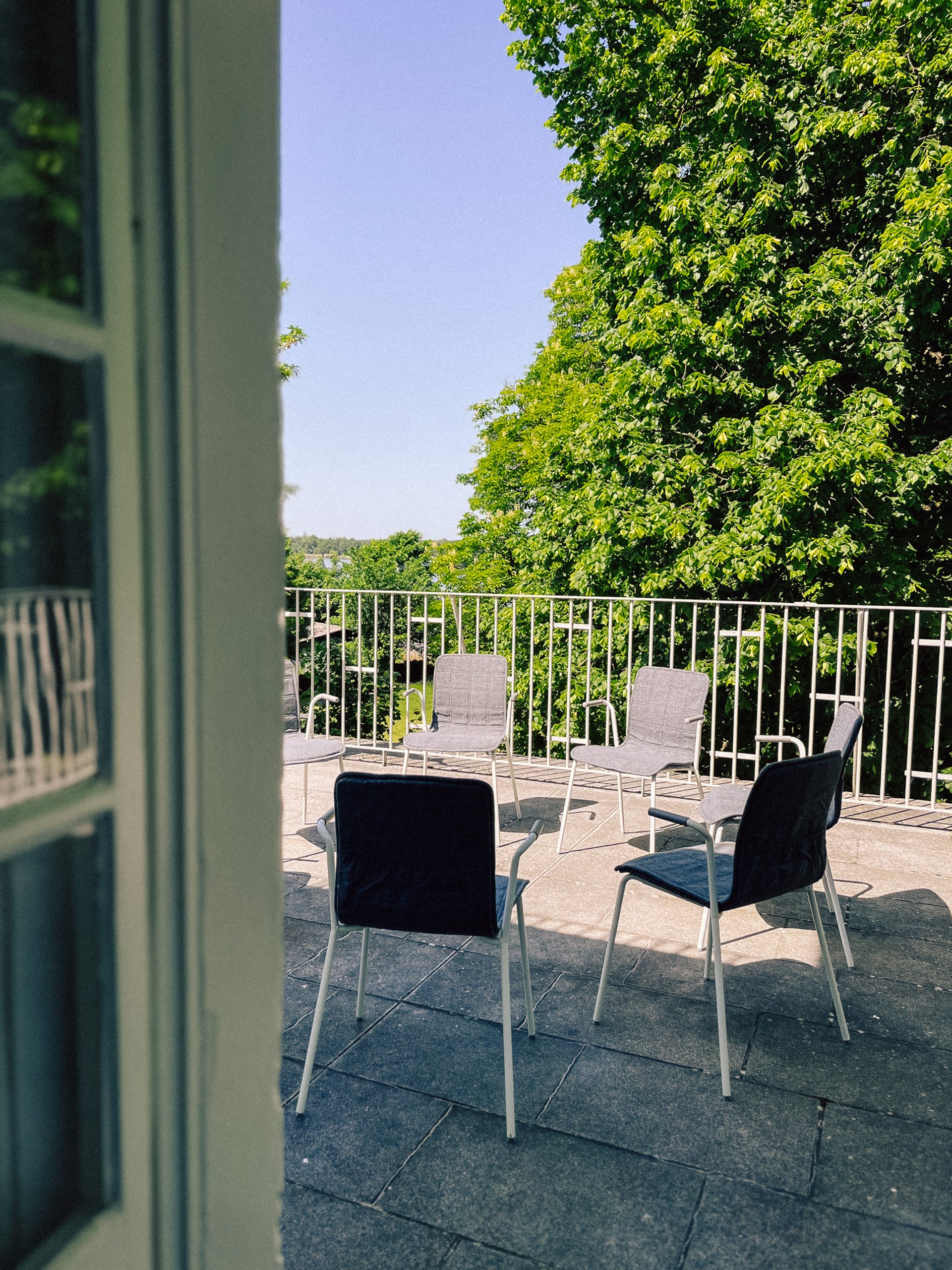 Dachterrasse am Workshopraum Seeblick mit Stühlen und Blick in die Baumkronen