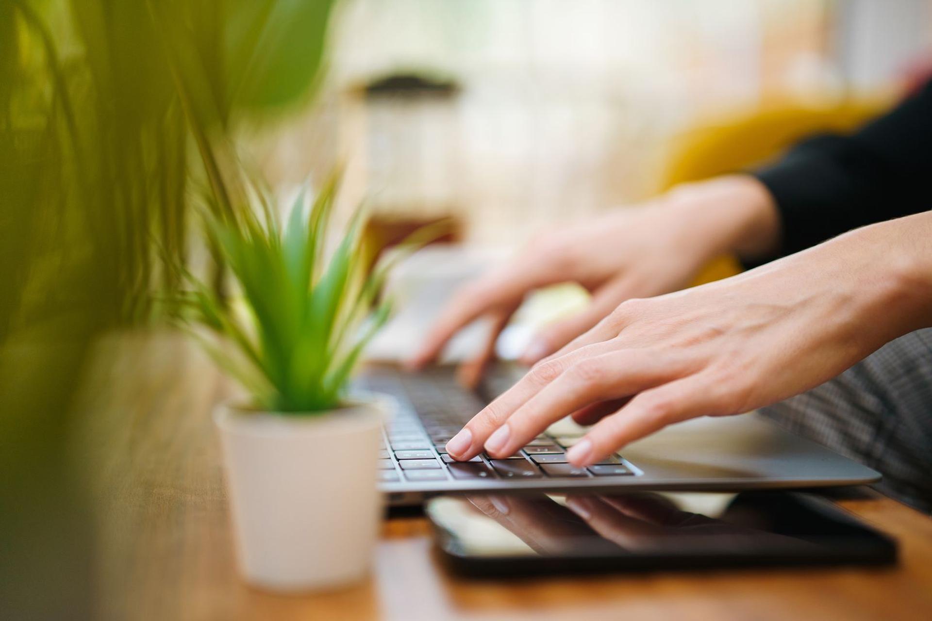 Personne tapant sur un ordinateur portable, mains en gros plan