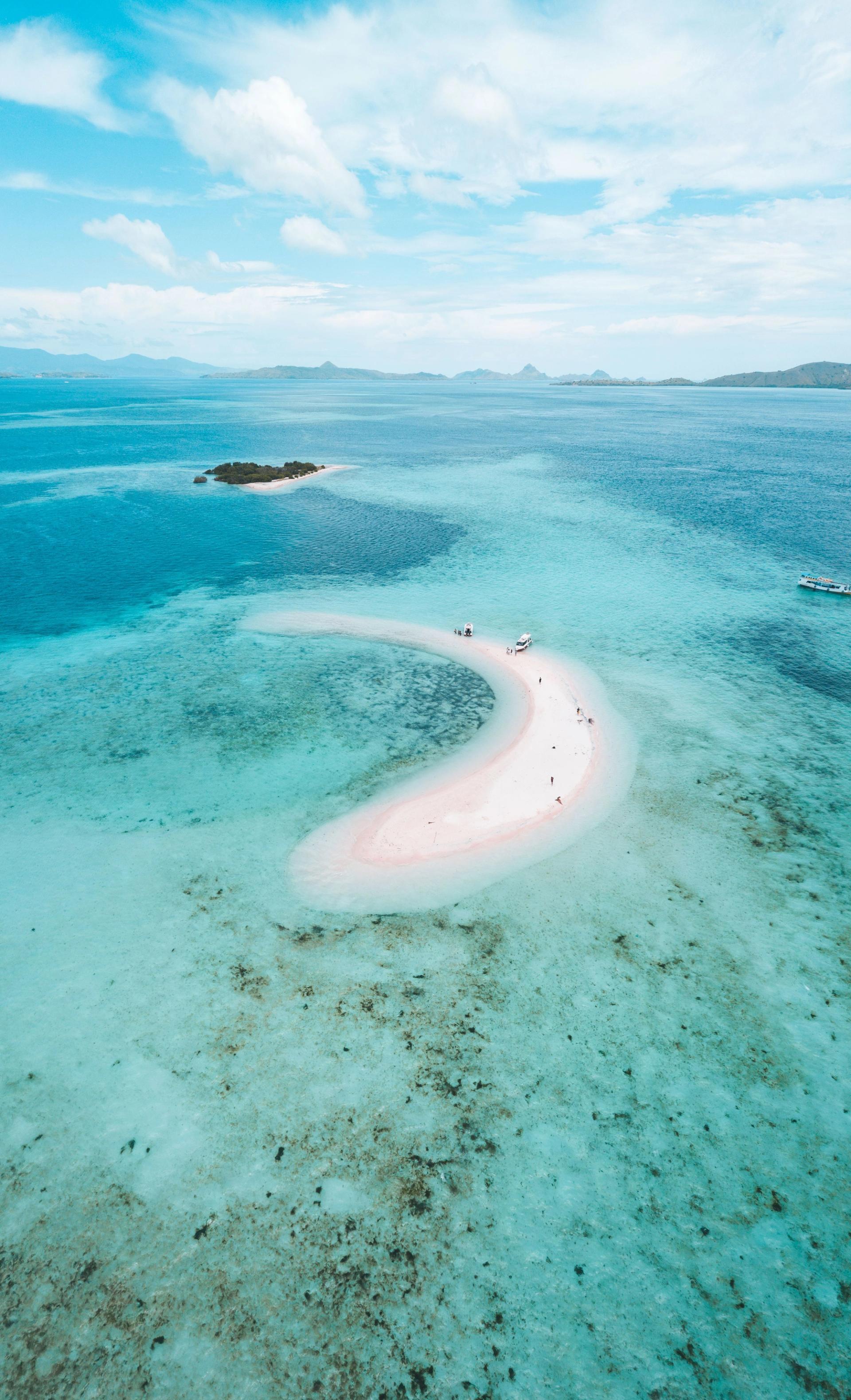 Aerial view of a pink sand beach and turquoise reef in Komodo National Park