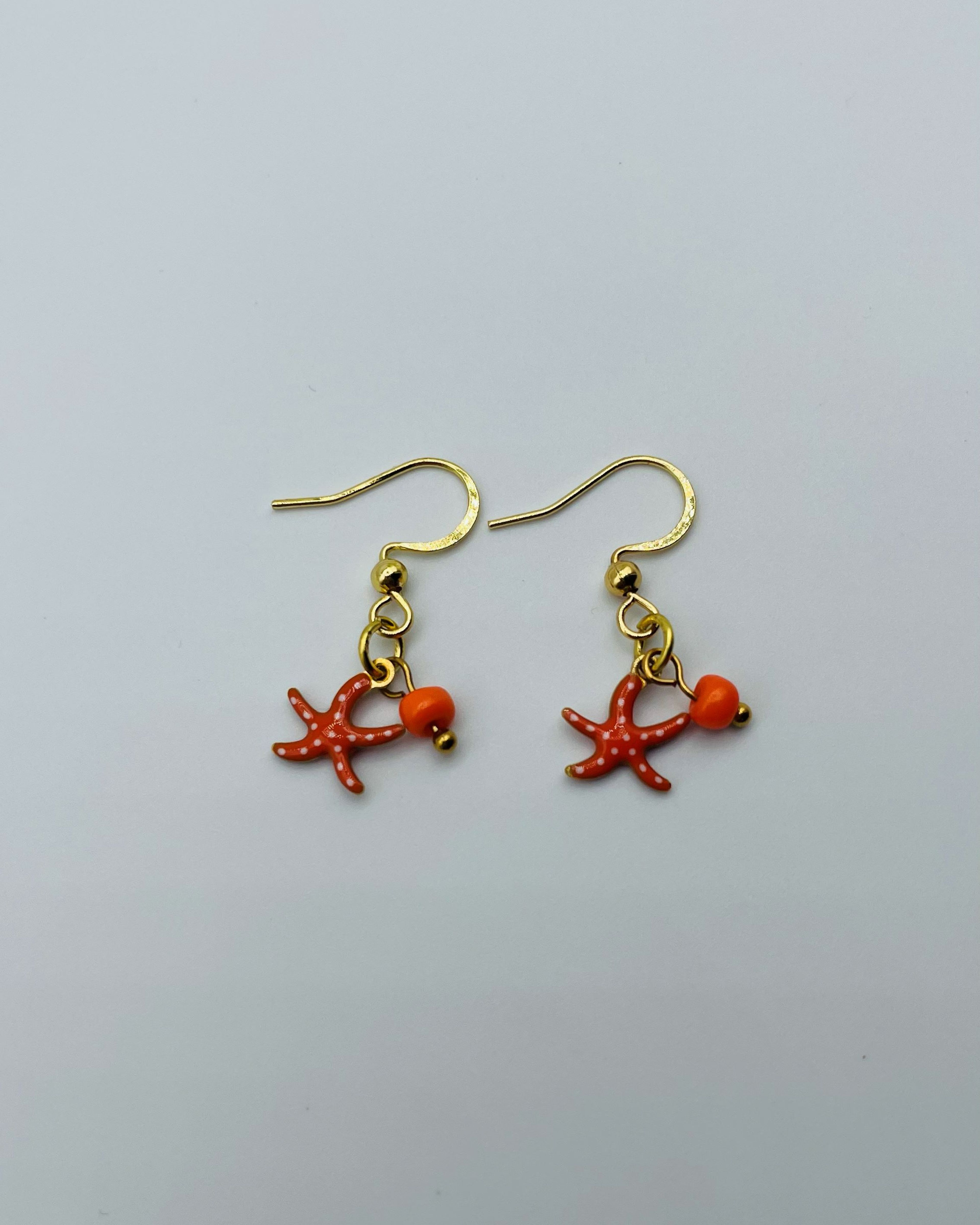 Gouden oorbellen met oranje zeester met stippen
