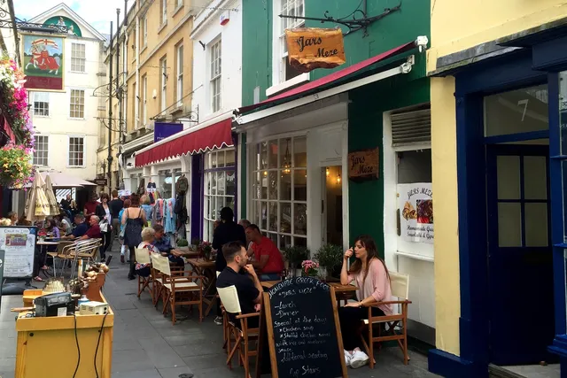 Jars Meze in Bath: View of people enjoying the outdoor seating area, overlooking the bustling Northumberland Place, creating a lively and vibrant atmosphere
