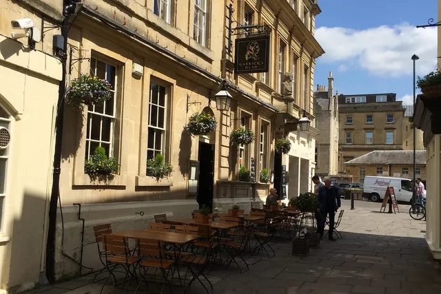 Garrick's Head in Bath: Front view with an inviting outdoor seating area, where patrons enjoy the charming ambiance of this historic pub
