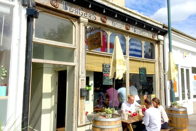 Burgers and Barrels in Bath: Vibrant front view with people enjoying outdoor seating, savouring delicious burgers and drinks in a lively atmosphere