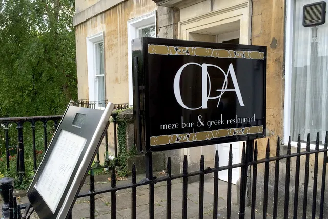 Opa in Bath: View of the signage, inviting guests to indulge in Greek flavours and enjoy the lively atmosphere of this charming restaurant
