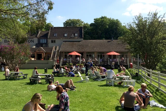 People relaxing at The Bathampton Mill beer garden during Summer in Bath