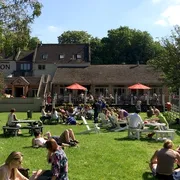 People relaxing at The Bathampton Mill beer garden during Summer in Bath