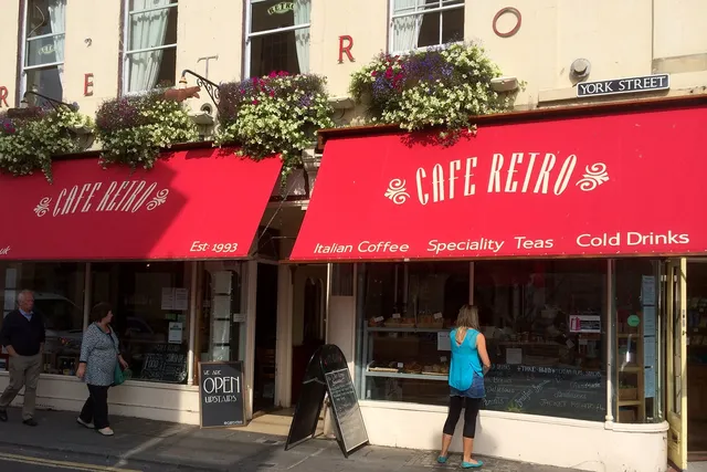 Cafe Retro in Bath: Quaint front view with people window shopping, offering a cozy ambiance and delectable treats