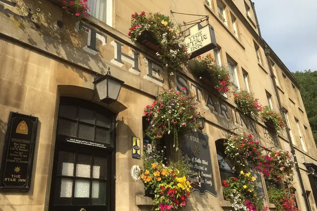 The Star in Bath: Front view featuring charming hanging plants, enhancing the inviting atmosphere of this cozy and popular pub