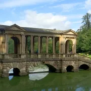 Palladian Bridge at Prior Park in Bath: Picturesque view of the iconic bridge, surrounded by lush greenery, evoking a sense of tranquility and beauty