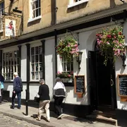 The Raven in Bath: Front view with people passing by, capturing the vibrant energy of this popular pub nestled in the city