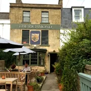 The Richmond in Bath: Front view with inviting outdoor seating area, where patrons enjoy the charming ambiance and delectable offerings of this popular establishment