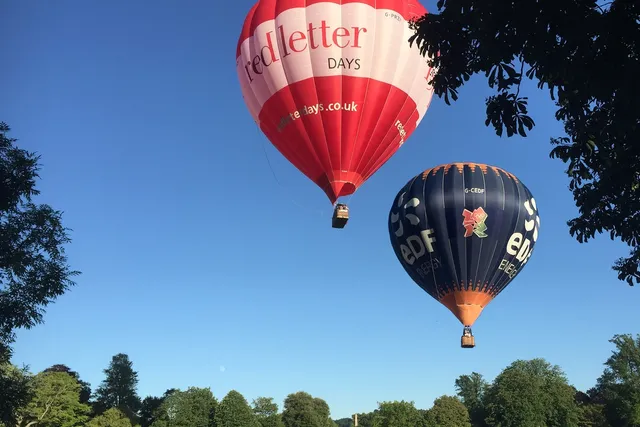 Hot air balloons lifting off at Royal Victoria Park in Bath