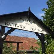 The Bathwick Boatman in Bath: Entrance signage of a waterfront venue, offering scenic views, delicious food, and a relaxing atmosphere