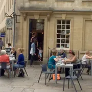 Society Cafe in Bath: Front view with people savouring the outdoor seating area, creating a vibrant atmosphere at this popular coffee spot