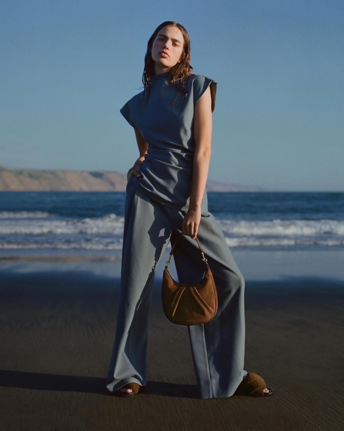 girl with handbag on beach