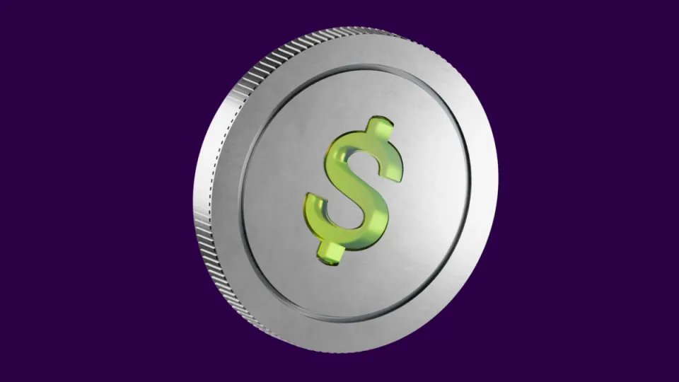 A silver coin with a glossy green dollar sign against a purple background.