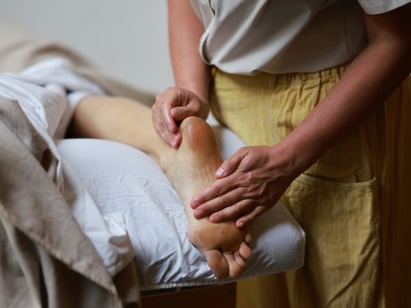 Hands working on the sole of a foot