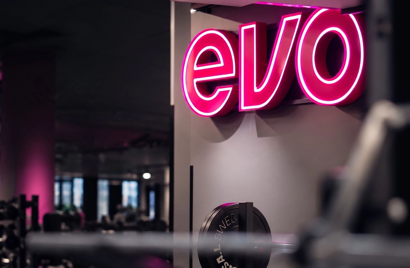 Evo neon sign above a gym floor